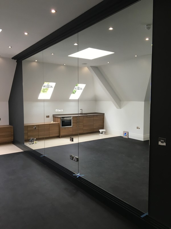 Frameless glass partition in loft conversion by Forest Gate glaziers