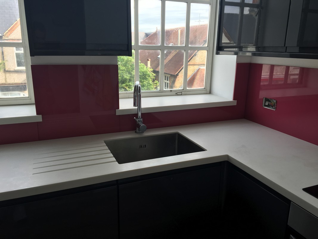 Deep plum coloured glass splashback in modern Forest Gate kitchen